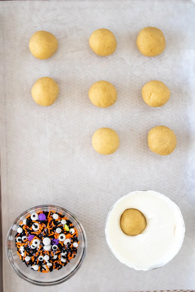 Cake ball dough being dipped into melted candy coating for Halloween cake truffles