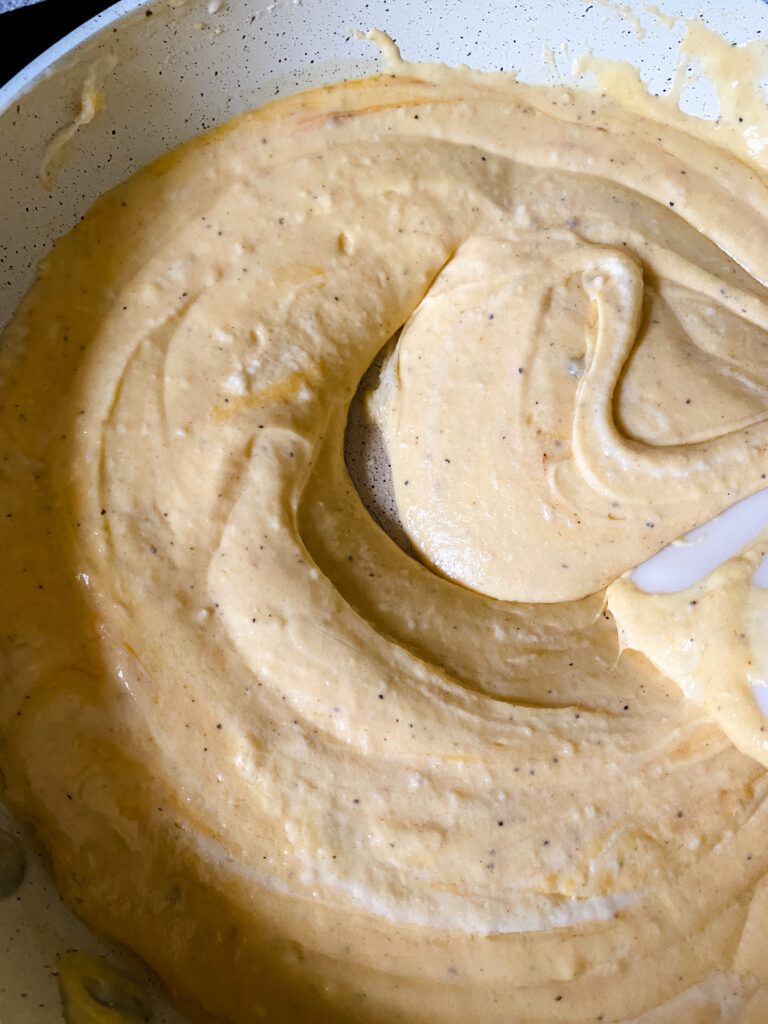 Finished homemade cheese sauce stirred until smooth and creamy for easy baked macaroni and cheese.