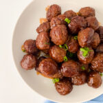 Plate of Baby Shower Meatballs coated in glossy grape jelly and BBQ sauce, served hot and ready to eat.