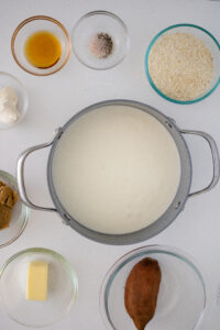 Water and heavy cream heating in a large pot for sweet potato grits