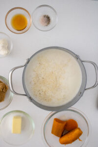 Quick-cooking grits being added to boiling water and cream for sweet potato grits