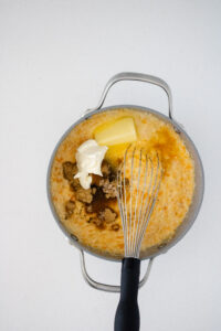 Sweet potato, cream cheese, butter, brown sugar, and maple syrup being added to cooked grits