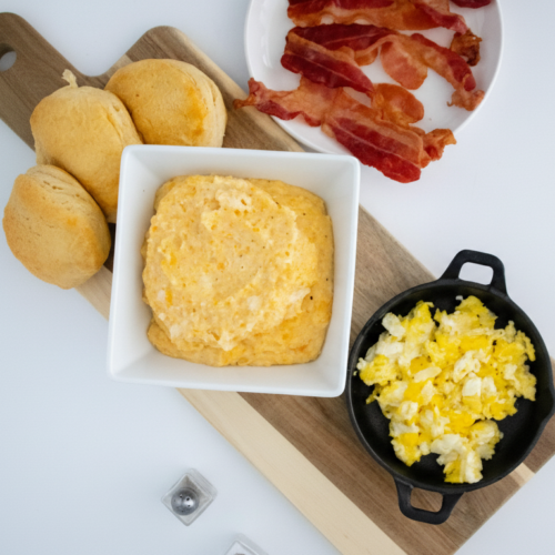 Sweet potato grits served with scrambled eggs, bacon, and biscuits