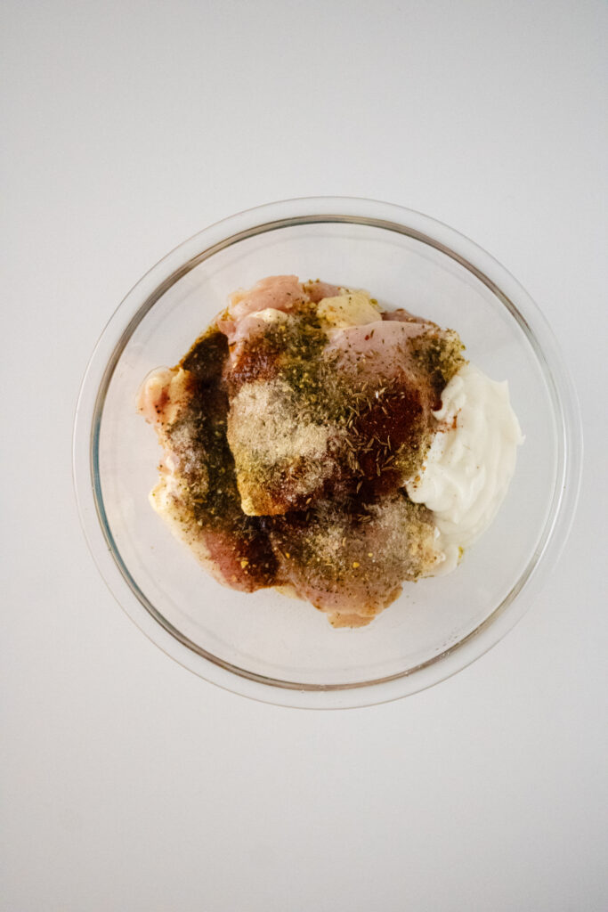 chicken in a bowl with spices and greek yogurt-pre mixed