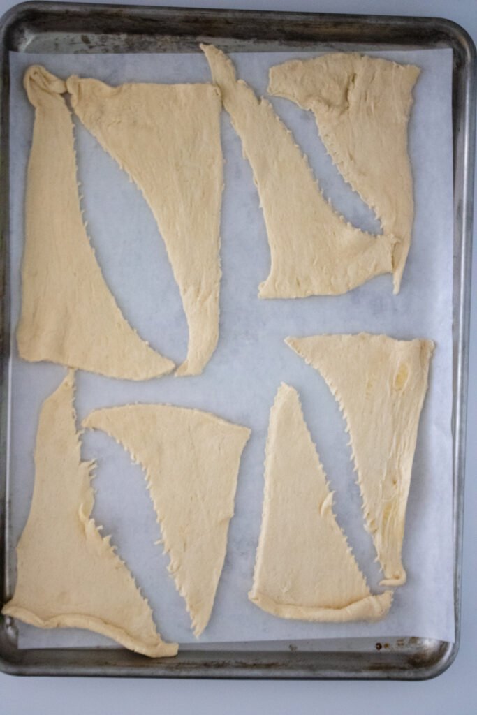 Crescent rolls on a parchment lined baking sheet