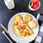Close-up of a breakfast quesadilla filled with colorful sautéed vegetables and melted cheese, served warm on a plate for a quick and easy morning meal.