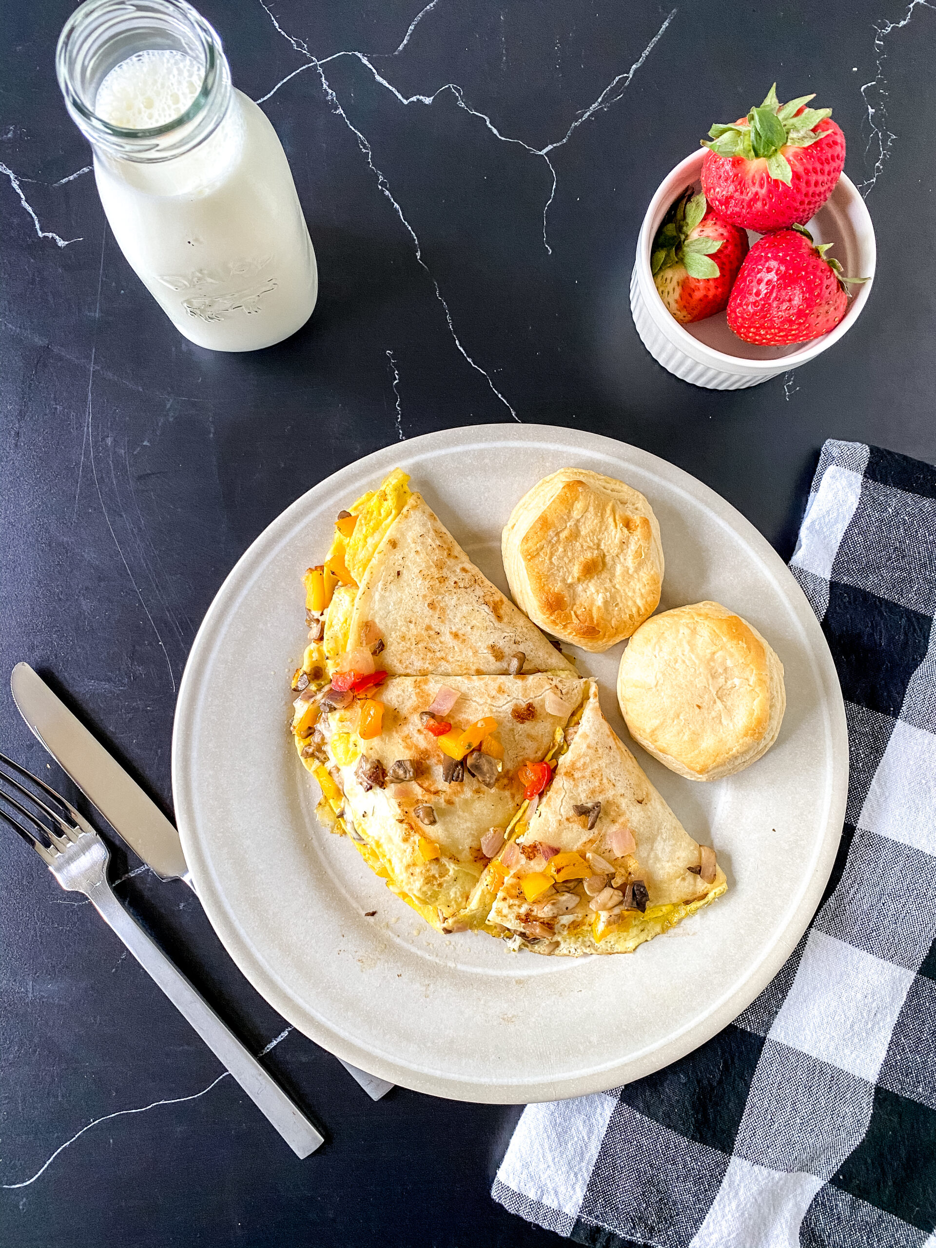 Close-up of a breakfast quesadilla filled with colorful sautéed vegetables and melted cheese, served warm on a plate for a quick and easy morning meal.