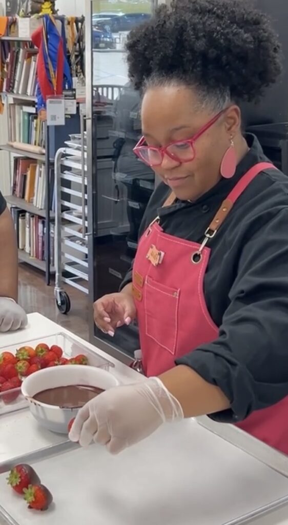 Cyd dipping fresh strawberries in melted chocolate. A candid photo that reflects her love of quick and easy homemade desserts.