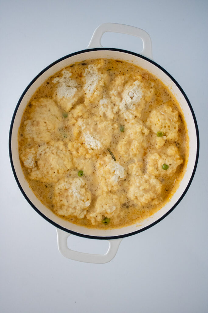 Cheddar Bay biscuit dumplings cooking in creamy chicken and dumplings soup.