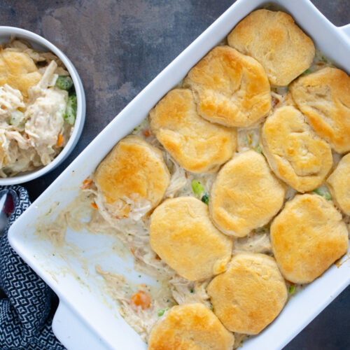 Chicken pot pie with biscuits baked in a casserole dish with creamy chicken, mixed vegetables, and flaky golden biscuit topping.