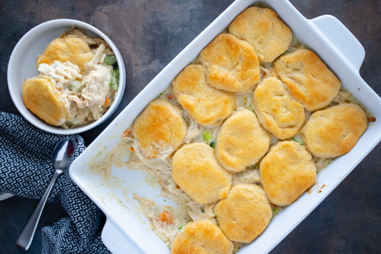 Chicken pot pie with biscuits baked in a casserole dish with creamy chicken, mixed vegetables, and flaky golden biscuit topping.