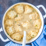 Fluffy Cheddar Bay dumplings finished cooking in a thick, creamy chicken and dumplings broth.