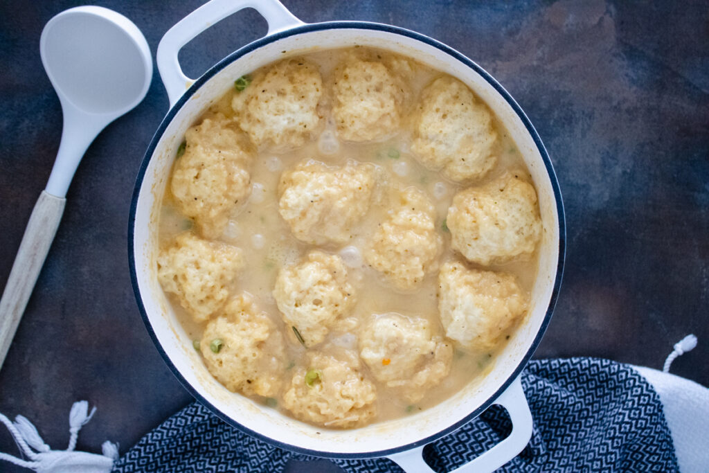 Fluffy Cheddar Bay dumplings finished cooking in a thick, creamy chicken and dumplings broth.