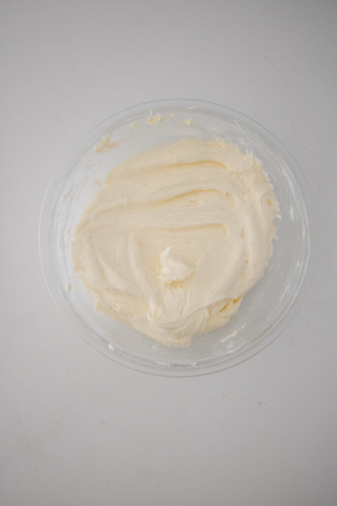 Smooth homemade cream cheese frosting mixed and ready for piping onto cupcakes.