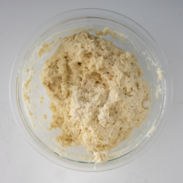Prepared Cheddar Bay biscuit dough for chicken and dumplings in a glass mixing bowl.