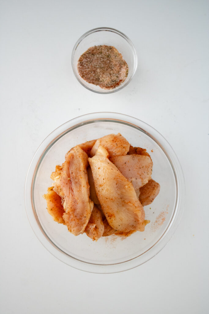Raw chicken coated with smoked paprika, garlic powder, oregano, salt, and black pepper for chicken and dumplings with biscuit mix.